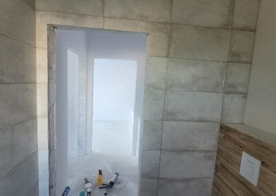 otwarta toaleta na korytarzu z drewnianą podłogą i kafelkami