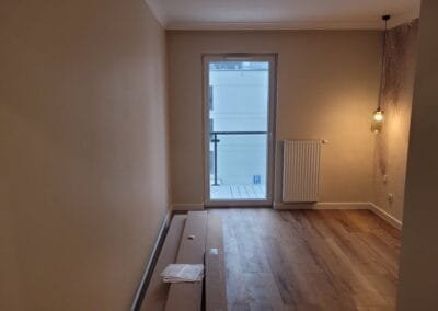 pokój z parkietem oknem i ogrzewaniem